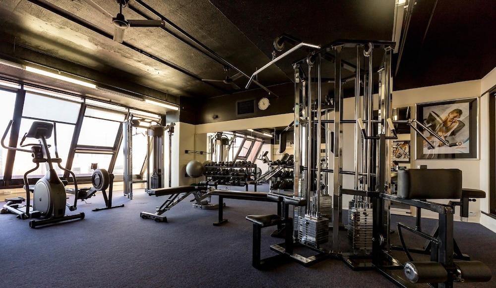 Hotel Stamford Grand Adelaide Glenelg Esterno foto The photo shows the interior of a gym or fitness room. It includes various exercise equipment, such as a multi-station weight machine and rowing machine. The space is well-lit with large windows allowing natural light in, and the walls are decorated 