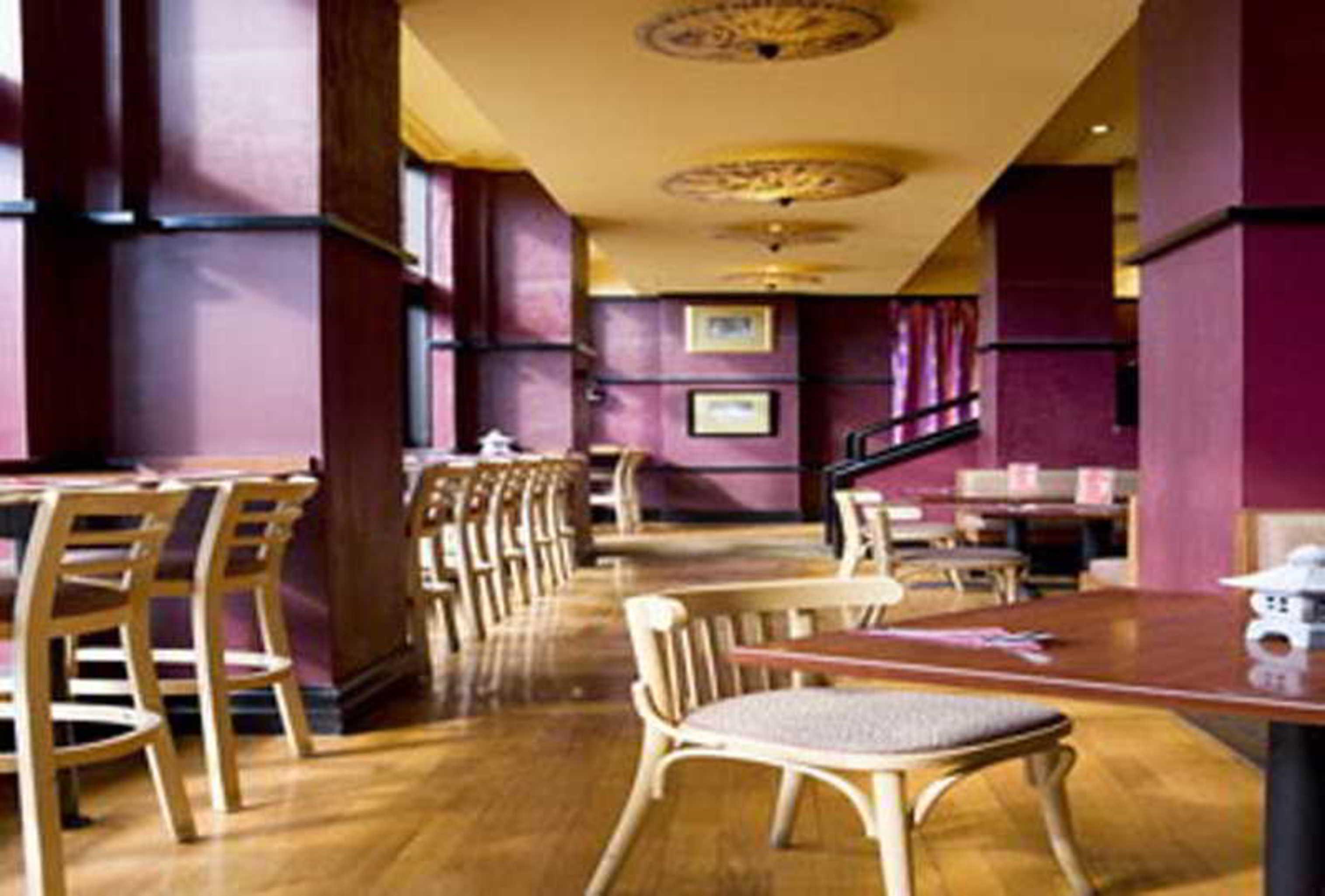 Hotel Stamford Grand Adelaide Glenelg Esterno foto The photo shows the interior of a restaurant. It features wooden flooring and a warm color palette, primarily using shades of burgundy and gold. There are several wooden chairs arranged around tables, with the seating area appearing spacious and invi